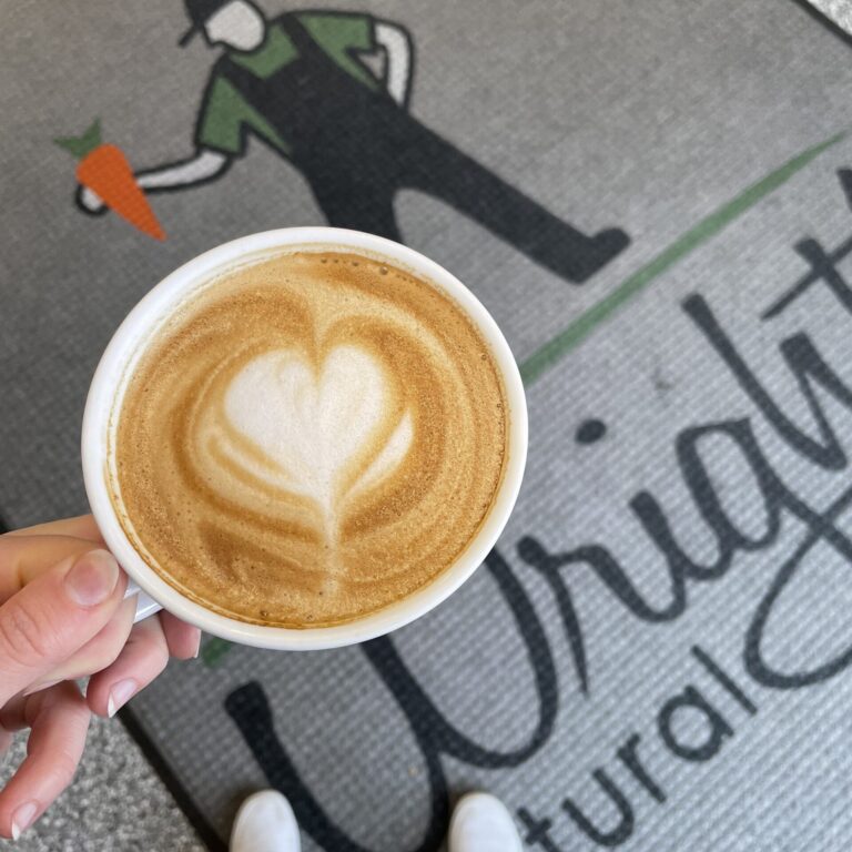 Coffee cup with heart design over Wright's Natural Market rug