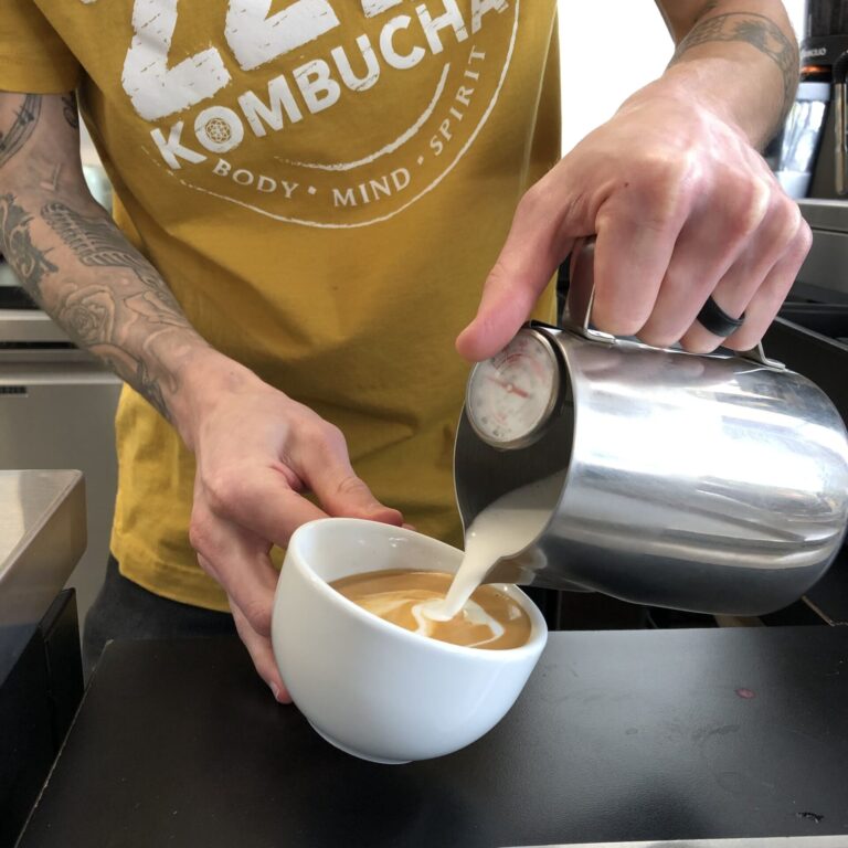 Employee pouring milk into cup